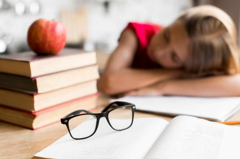Уставшая школьница спит за партой